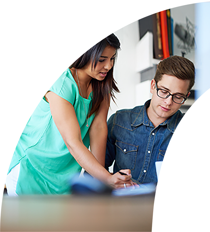 Bridgehead team member leaning over another team member as they both look at a notepad